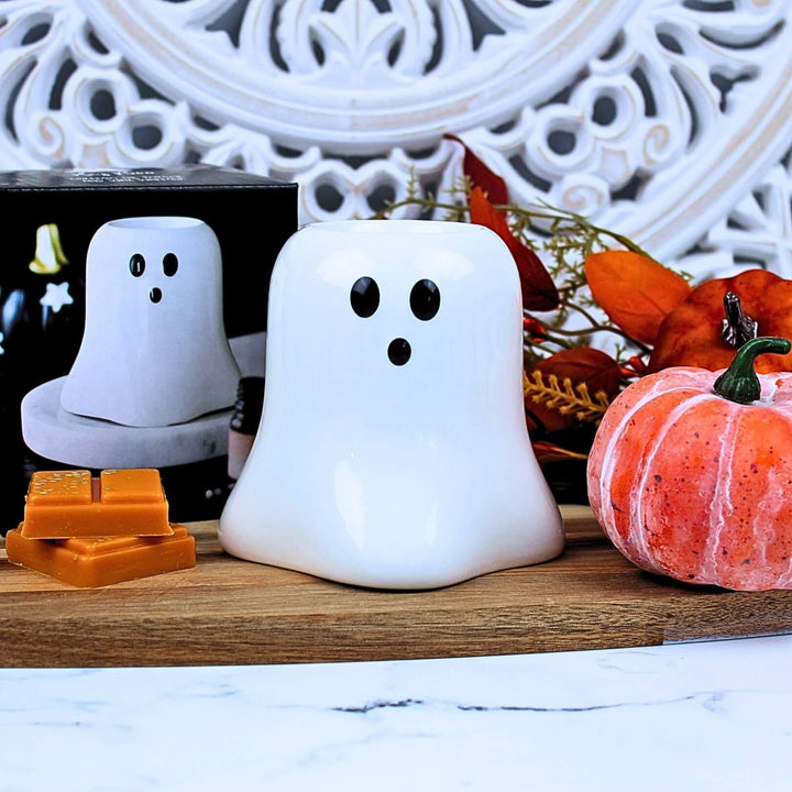 Front view of Boo Ghost wax melt burner with minimalist ghost face, surrounded by pumpkins and autumn decor