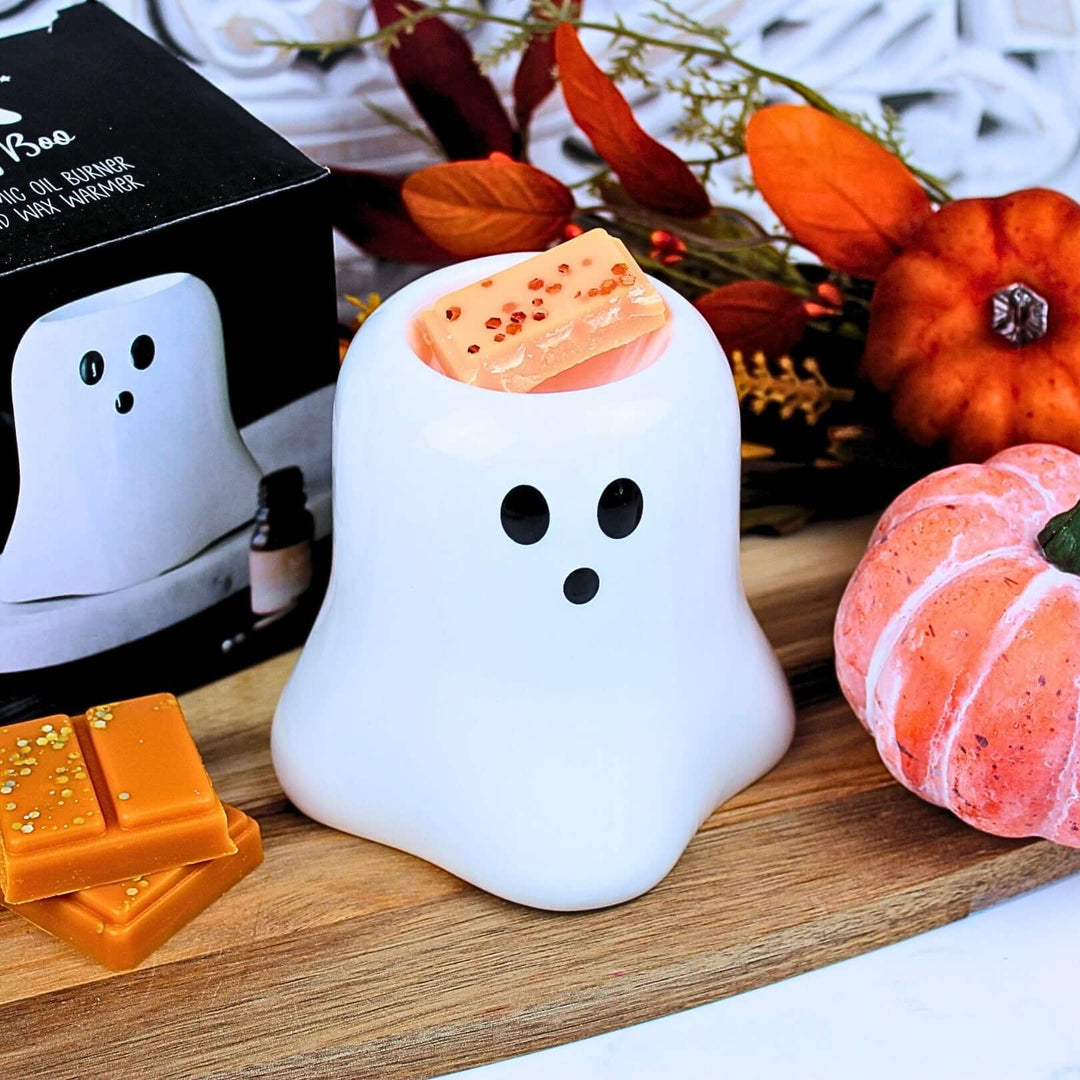 Top view of Boo Ghost ceramic wax melt burner with orange wax melt, styled for autumn and halloween