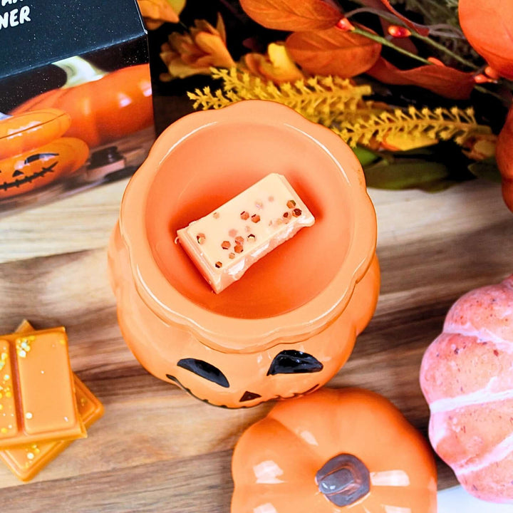 Top view of XL pumpkin wax melt burner with autumn wax melt inside, surrounded by seasonal foliage