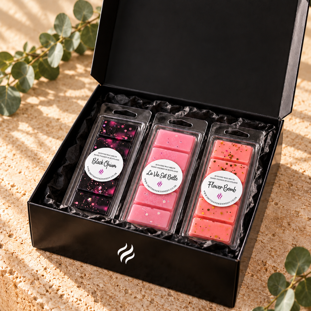 Smith &amp; Kennedy Scents black magnetic storage box holding Black Opium, La Vie Est Belle and Flower Bomb packaged wax melt snap bars as an example of use; contents sold separately.
