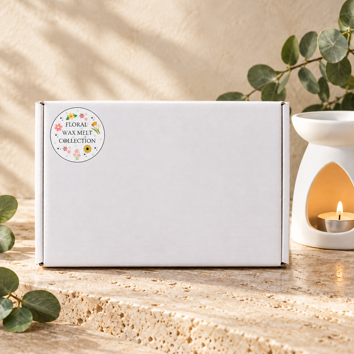 Floral Wax Melt Collection white gift box with its collection sticker, beside a white wax burner and eucalyptus leaves, by Smith &amp; Kennedy Scents.