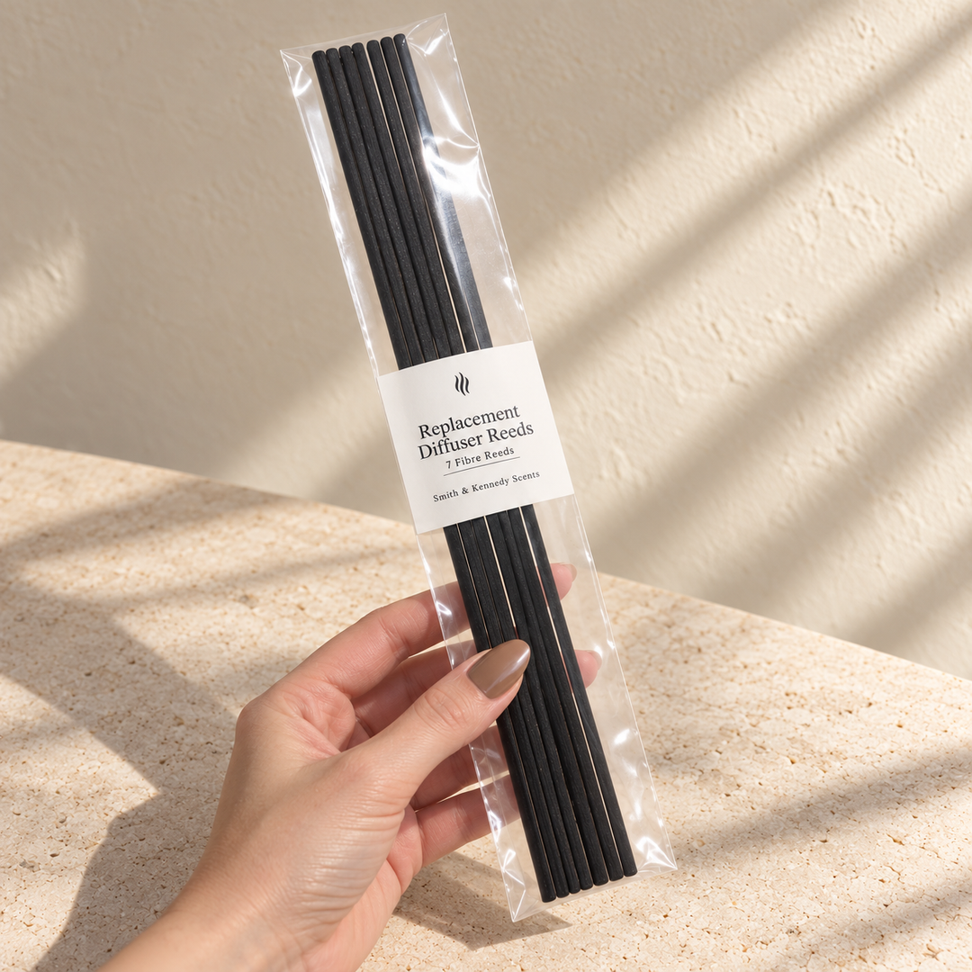 Hand holding a sealed pack of 7 black fibre replacement diffuser reeds to show their 250mm length