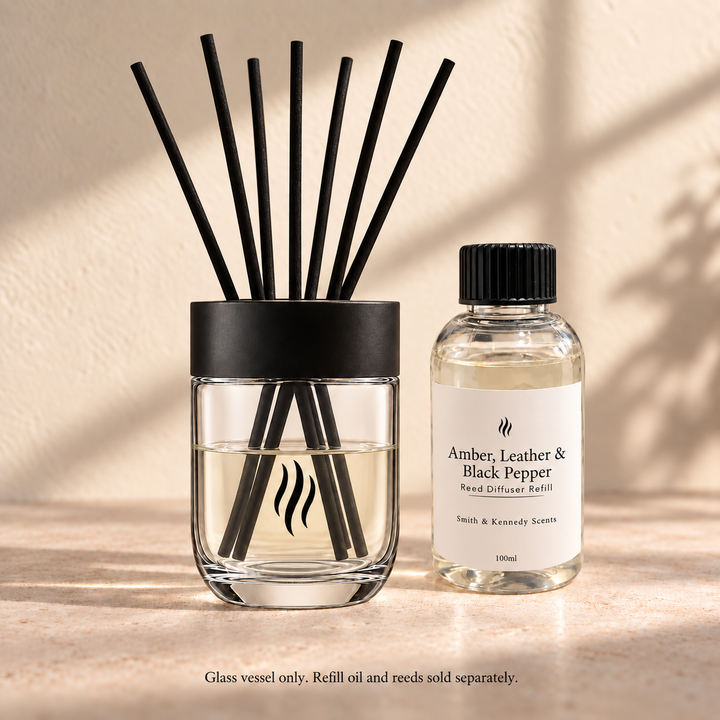 Reusable reed diffuser glass with seven reeds beside portrait-label refill; oil and reeds sold separately