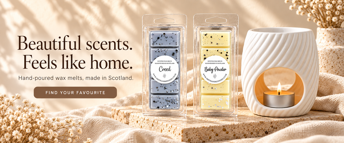 Creed and Baby Powder wax melt snap bars beside a White Wave tealight burner on warm stone, by Smith & Kennedy Scents.