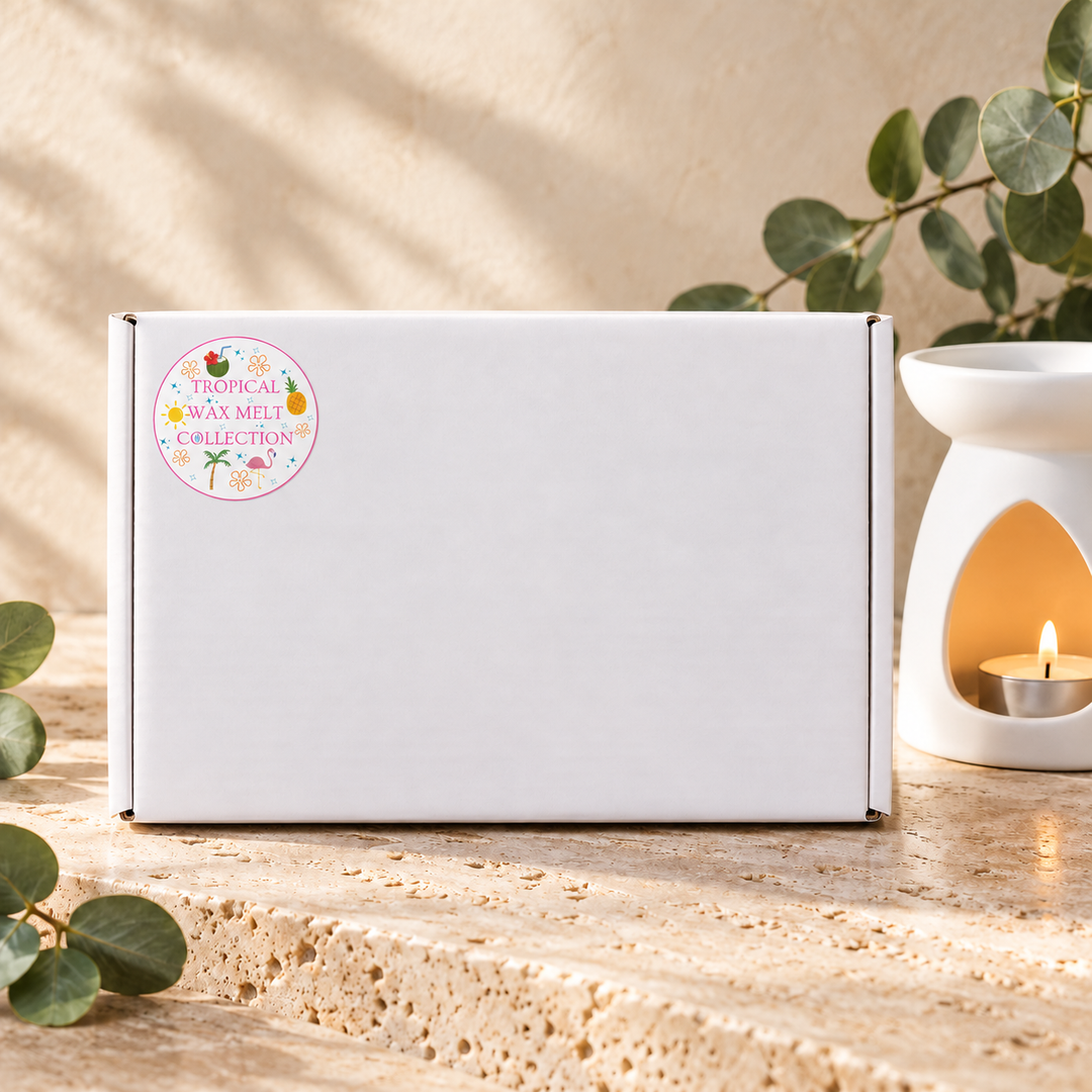 Tropical Wax Melt Collection white gift box with its collection sticker, beside a white wax burner and eucalyptus leaves, by Smith &amp; Kennedy Scents.